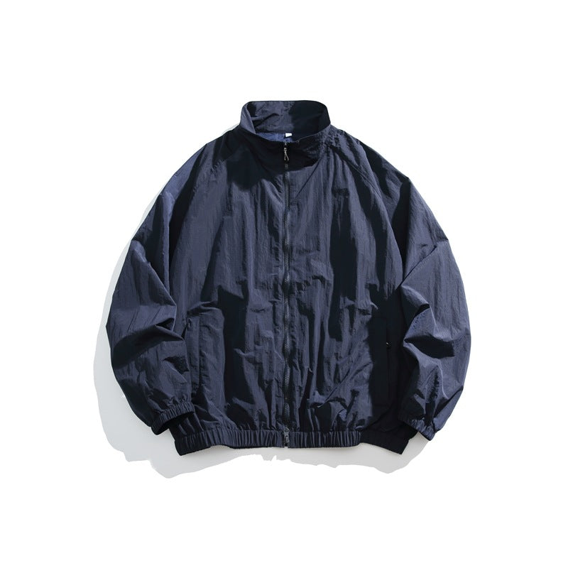 Navy stand-collar zip-front jacket laid flat with elastic cuffs and hem