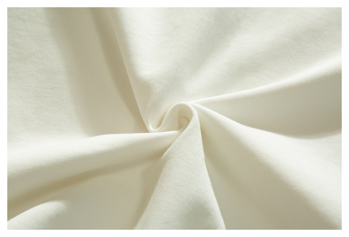 Close-up of the white T-shirt fabric gathered into folds.