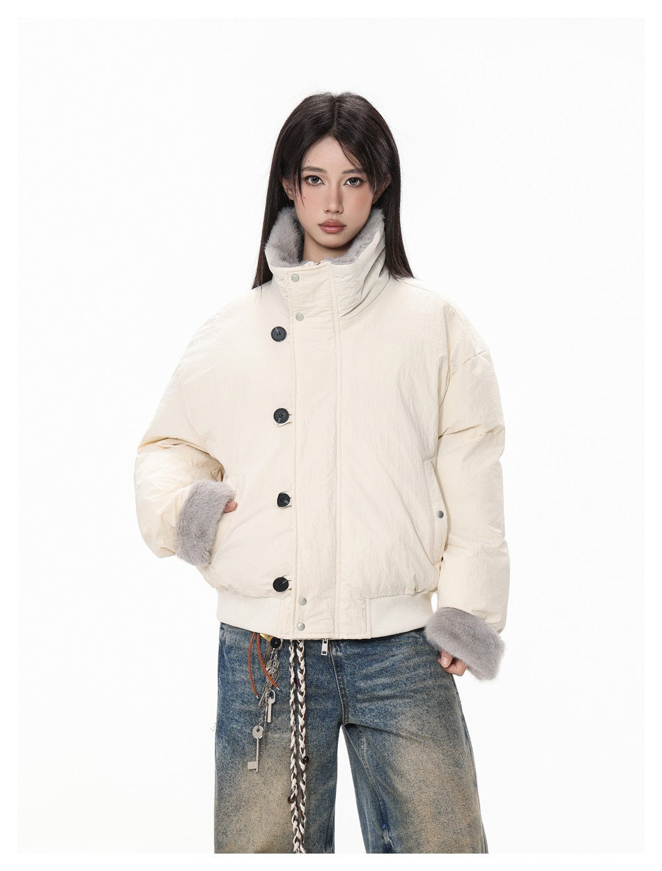 Model wearing an ivory oversized jacket with a high gray-fur-lined collar, fur cuffs, and large dark buttons.