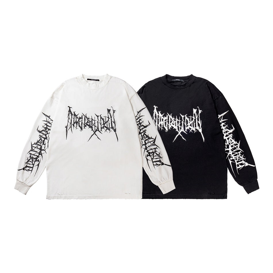 White and black long-sleeve crew-neck shirts displayed together, each with bold distressed graphics on the front and sleeves.