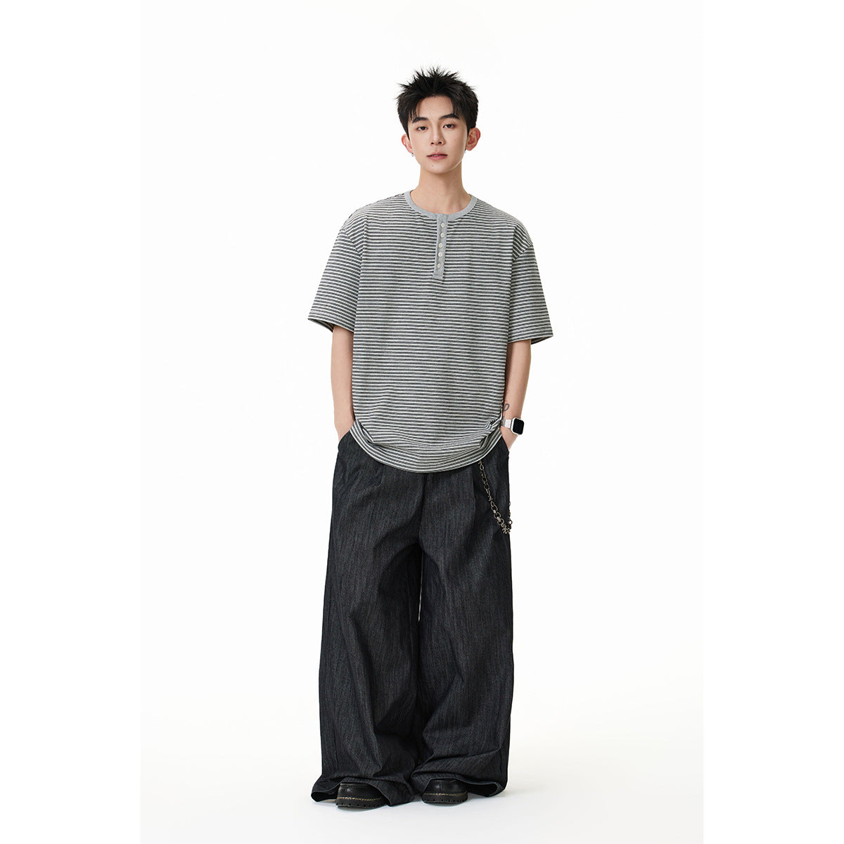 Full-length model wearing a gray and dark striped short-sleeve henley with wide-leg dark trousers.