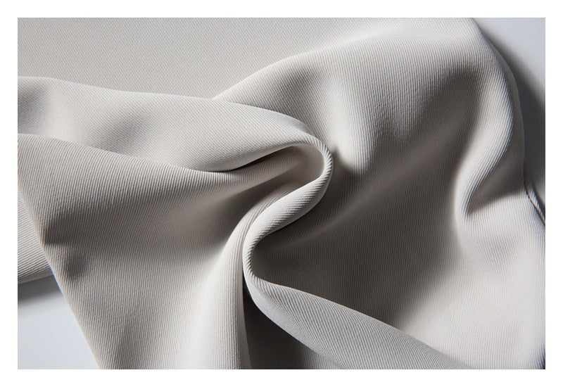 Close-up of pale gray, finely ribbed fabric draped in soft folds.