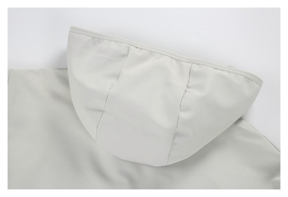 Close-up of a light gray jacket hood with curved panel seams and stitched edging.