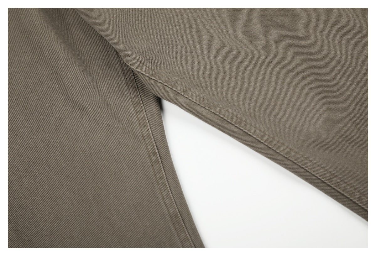 Close-up of taupe-gray pants showing the inner leg seam and stitching.