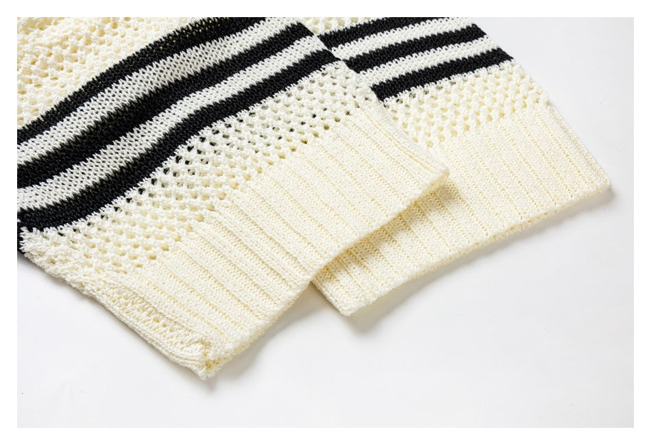 Close-up of cream knit sleeve cuffs with black and cream stripes above ribbed edges.