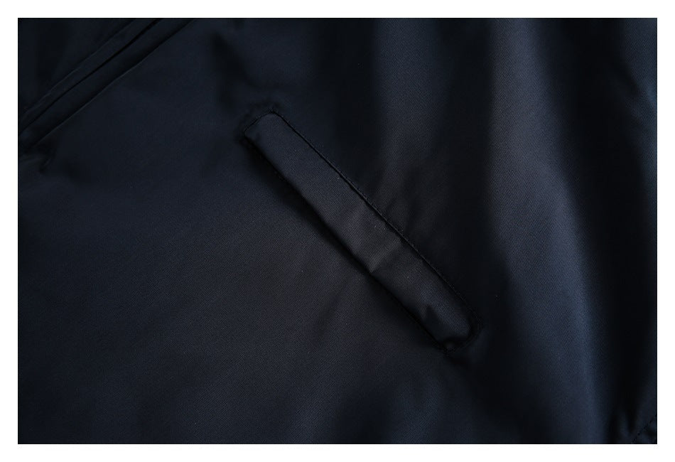 Close-up of a diagonal welt pocket on dark navy jacket fabric.