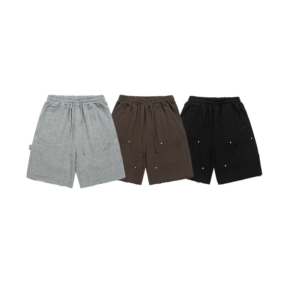 Front view of drawstring shorts in gray, brown, and black, with pockets and raw hems.