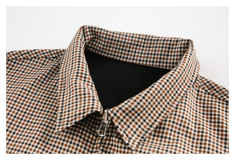 Close-up of a pointed brown, cream, and black checked collar with a silver zipper.