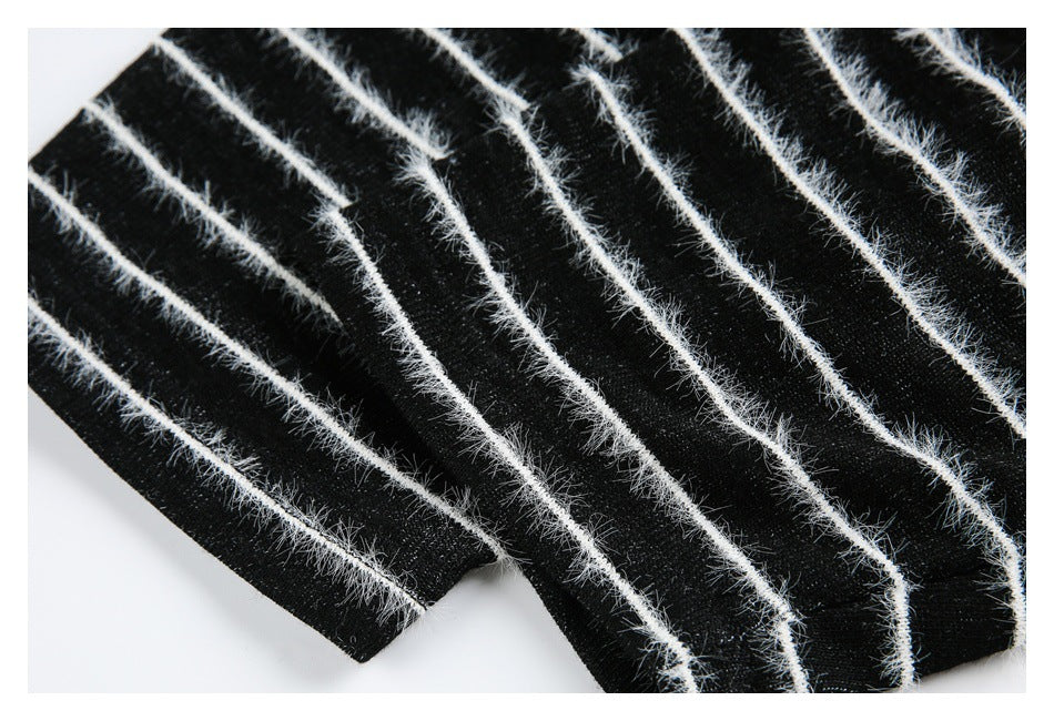 Close-up of black fabric with repeated fuzzy white diagonal stripes.