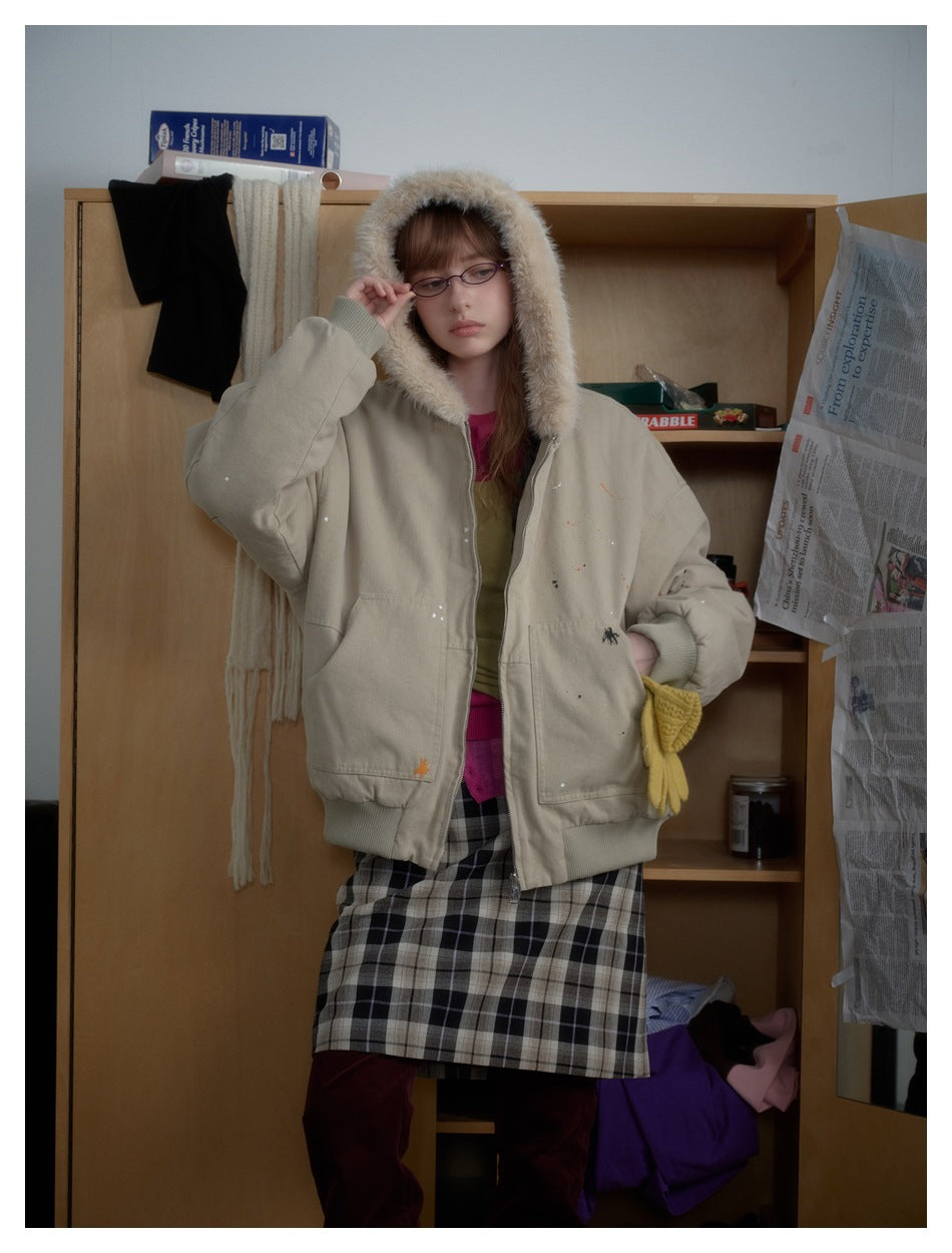 Model wearing a light beige zip-front jacket with its plush-lined hood up, ribbed cuffs, and large front pockets.