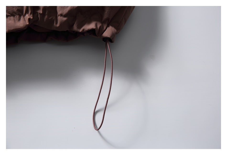 Close-up of one adjustment cord loop hanging from the vest's gathered hem.