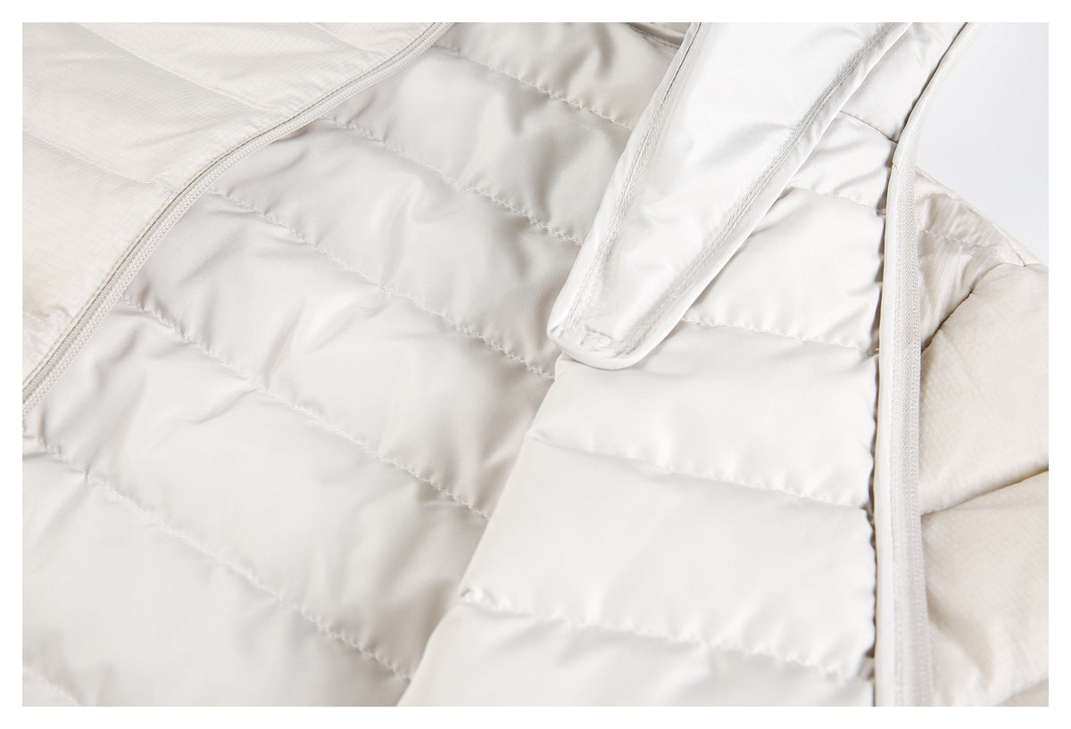 Close-up of the ivory jacket's quilted interior, zipper, and hanging loop.
