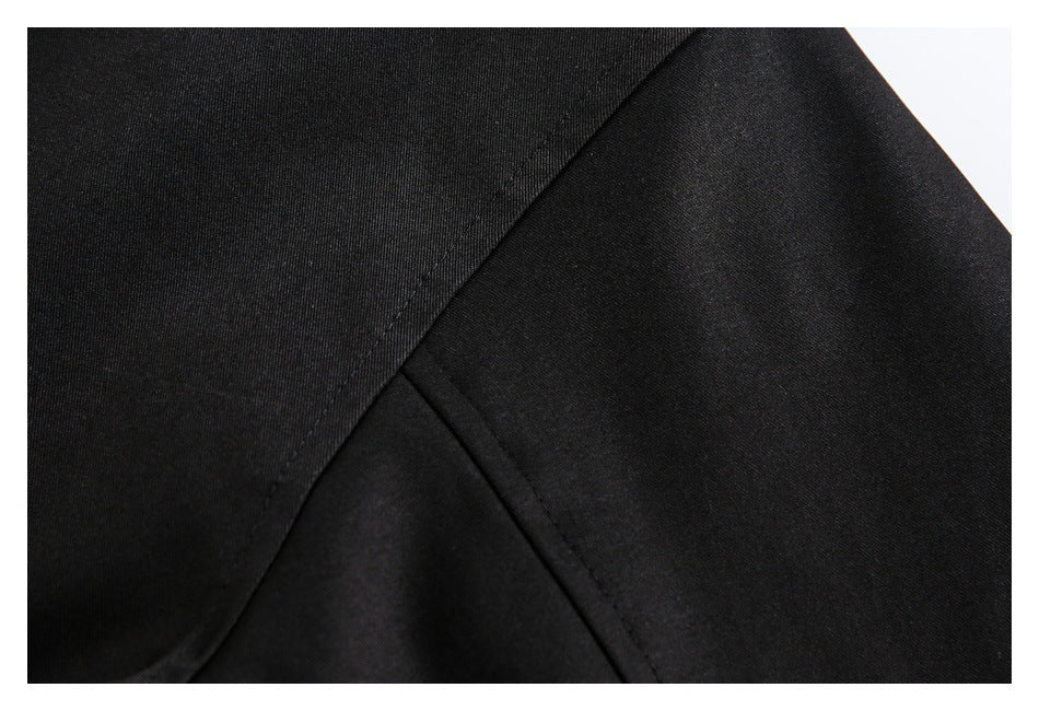Close-up of black jacket fabric and intersecting stitched seams.