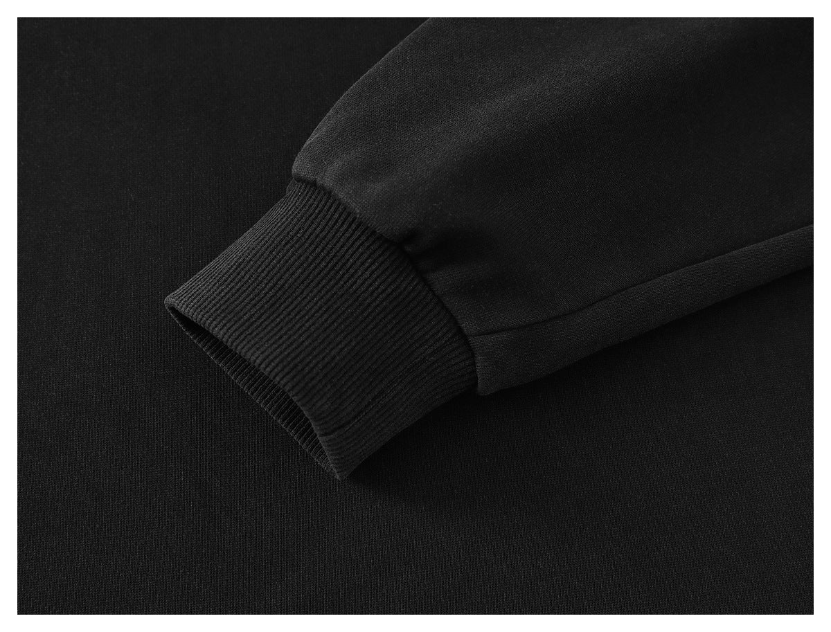 Close-up of a black sleeve ending in a wide ribbed cuff with visible stitching.