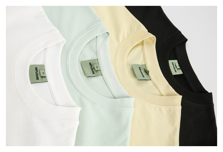 Close-up of four T-shirt necklines in white, pale mint, light yellow, and black.