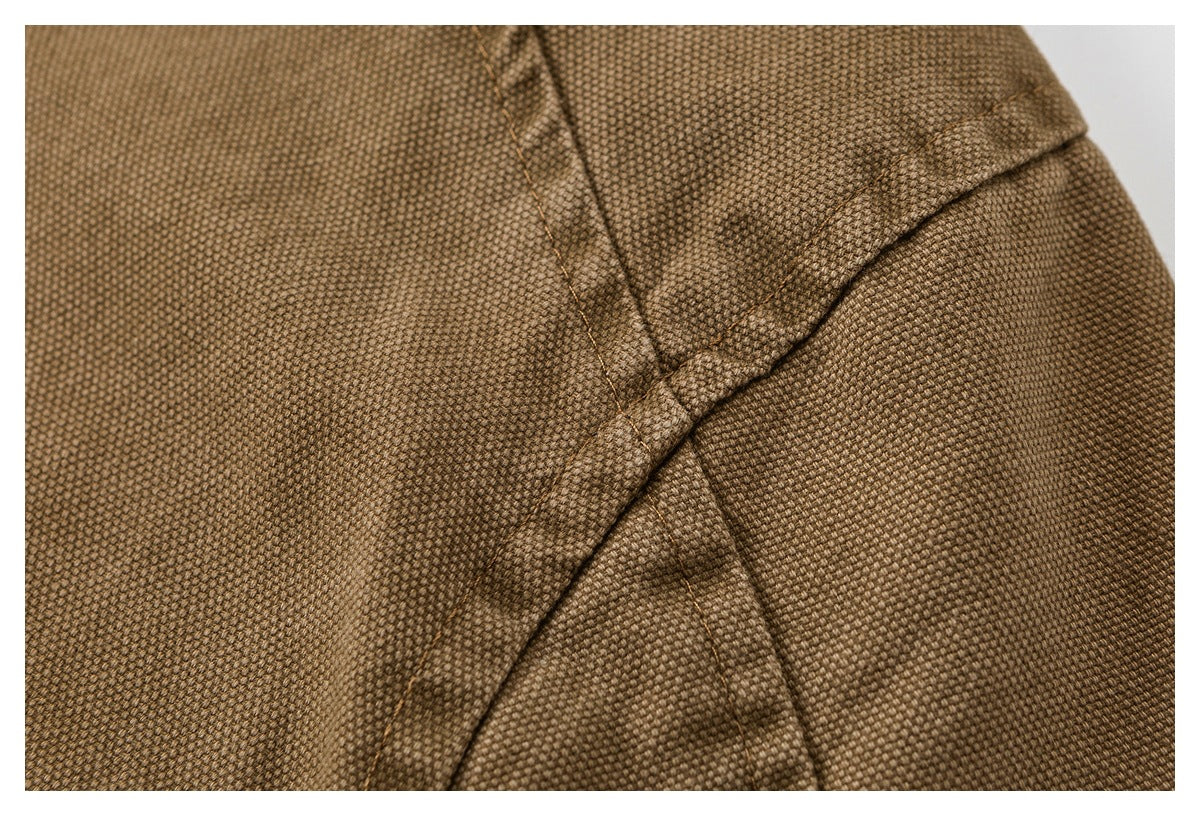 Close-up of brown textured garment fabric with overlapping stitched seams.