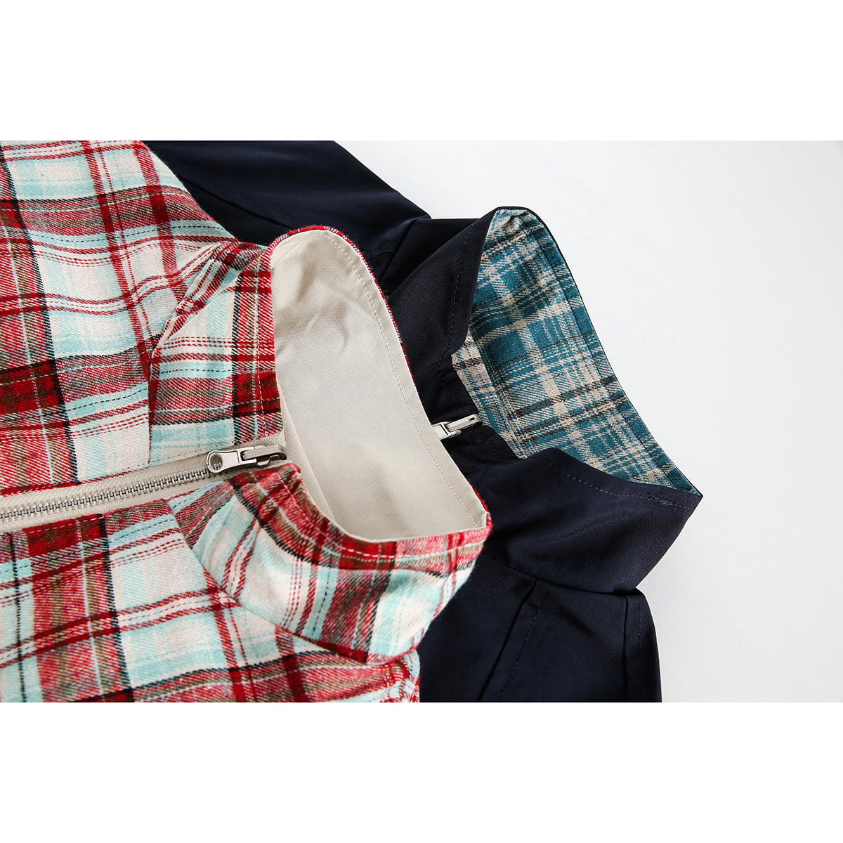 Close-up of a red, white, and pale blue plaid jacket with a silver zipper, cream lining, and navy contrast fabric.