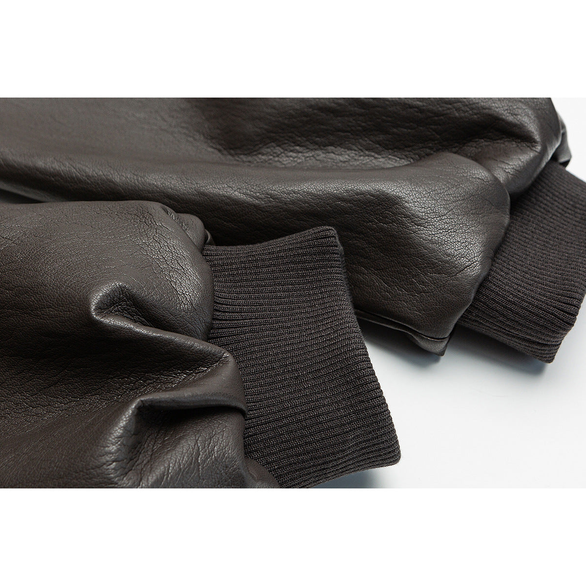 Close-up of the dark brown jacket's sleeve ends and dark ribbed cuffs.