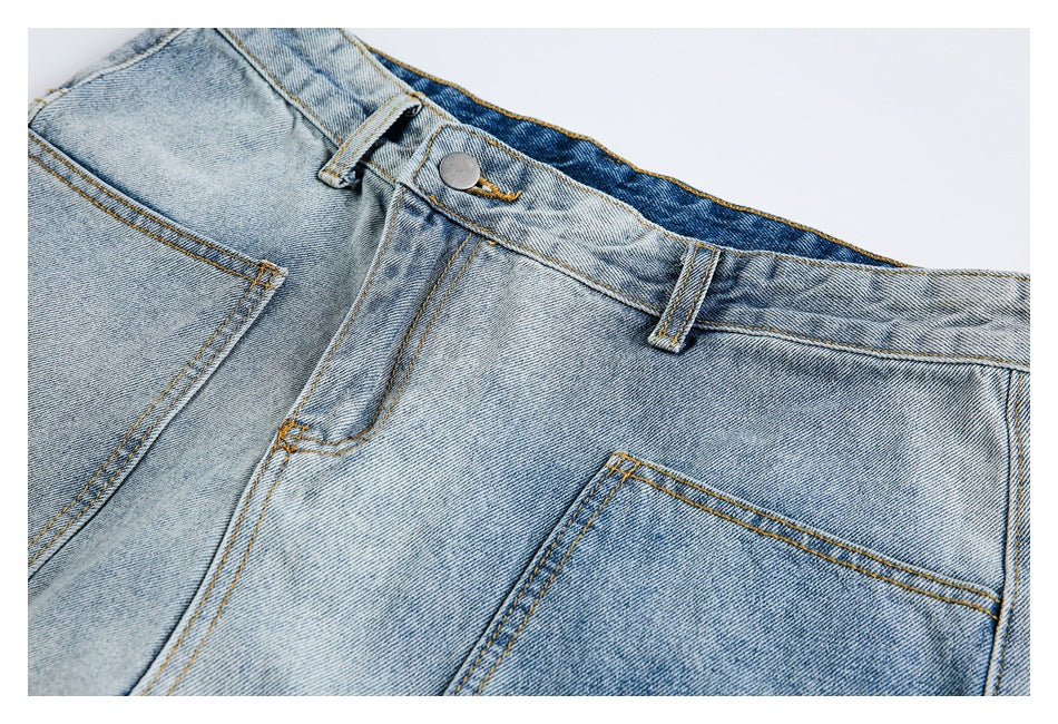 Close-up of light-wash jeans showing the waistband, button, belt loop, front pocket, and contrasting stitching.