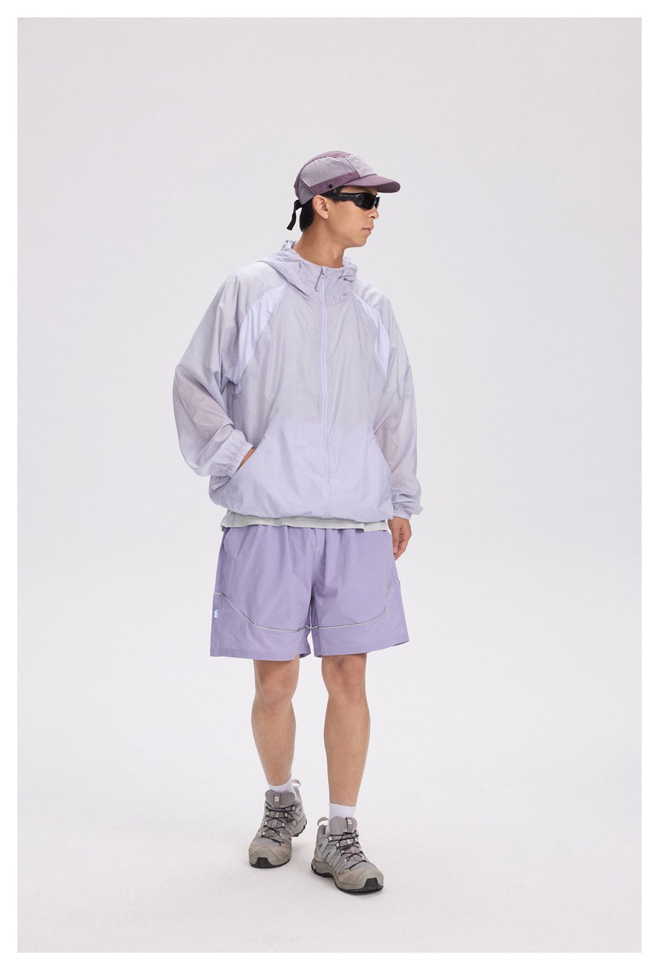 Model in a pale lavender hooded zip jacket and matching shorts, shown from a three-quarter angle.