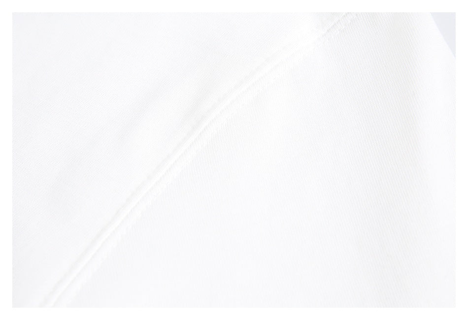 Close-up of white fabric with a diagonal stitched seam and fine knit texture.
