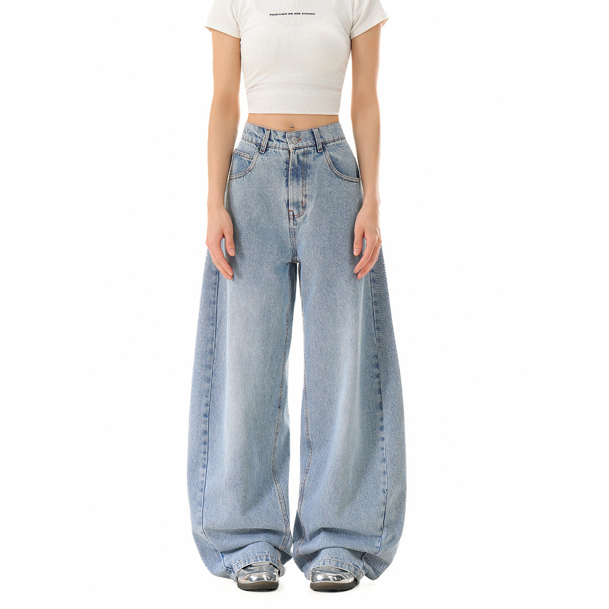 Front view of a model wearing light-wash, wide-leg jeans and a white cropped T-shirt with small English chest text.