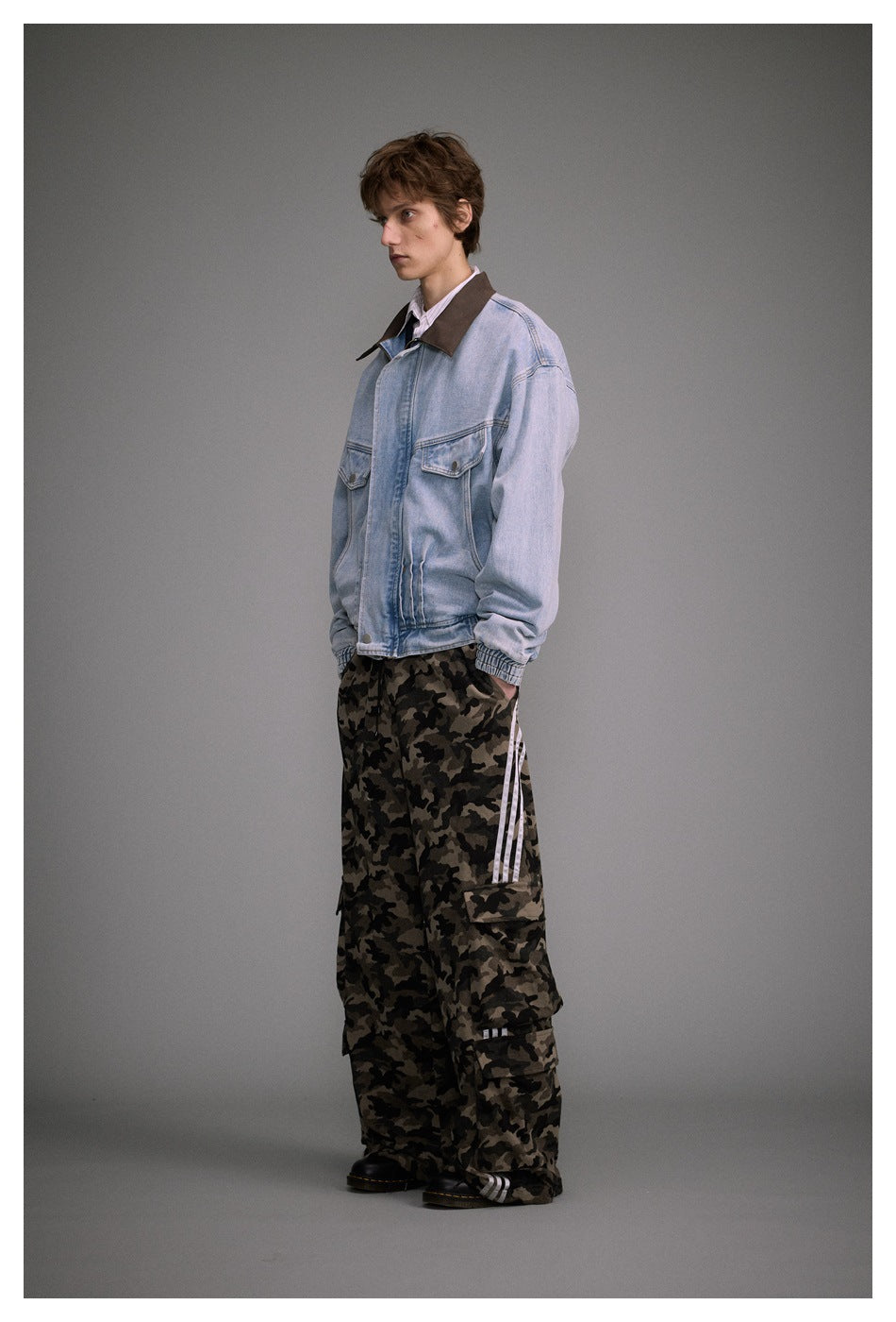 Model in a light blue denim jacket with brown collar and camouflage cargo pants, side view