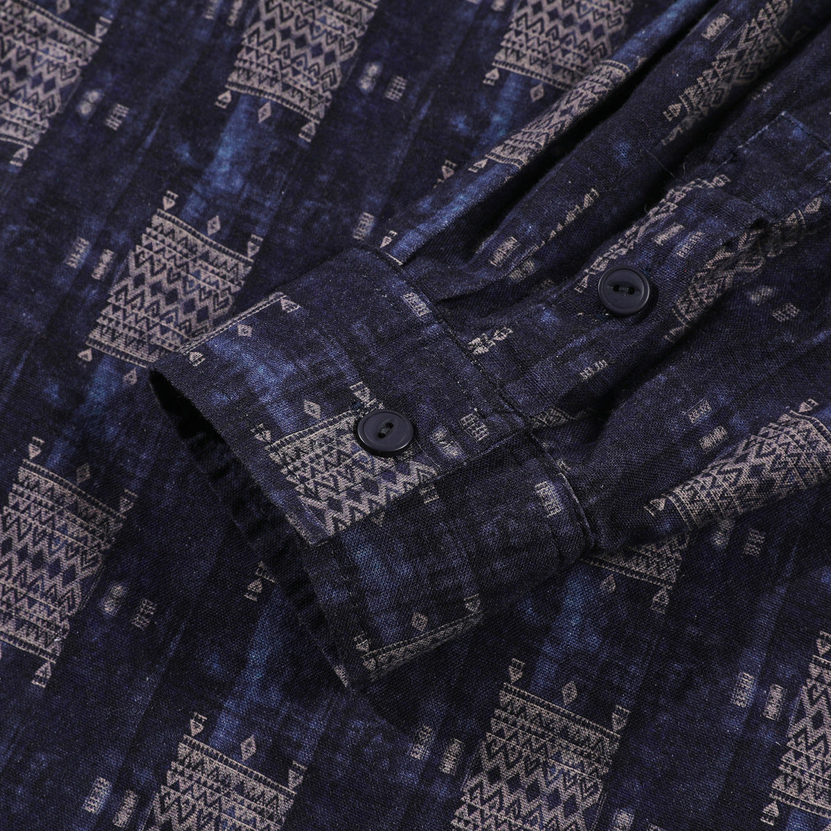 Close-up of a dark patterned shirt cuff with two black buttons.