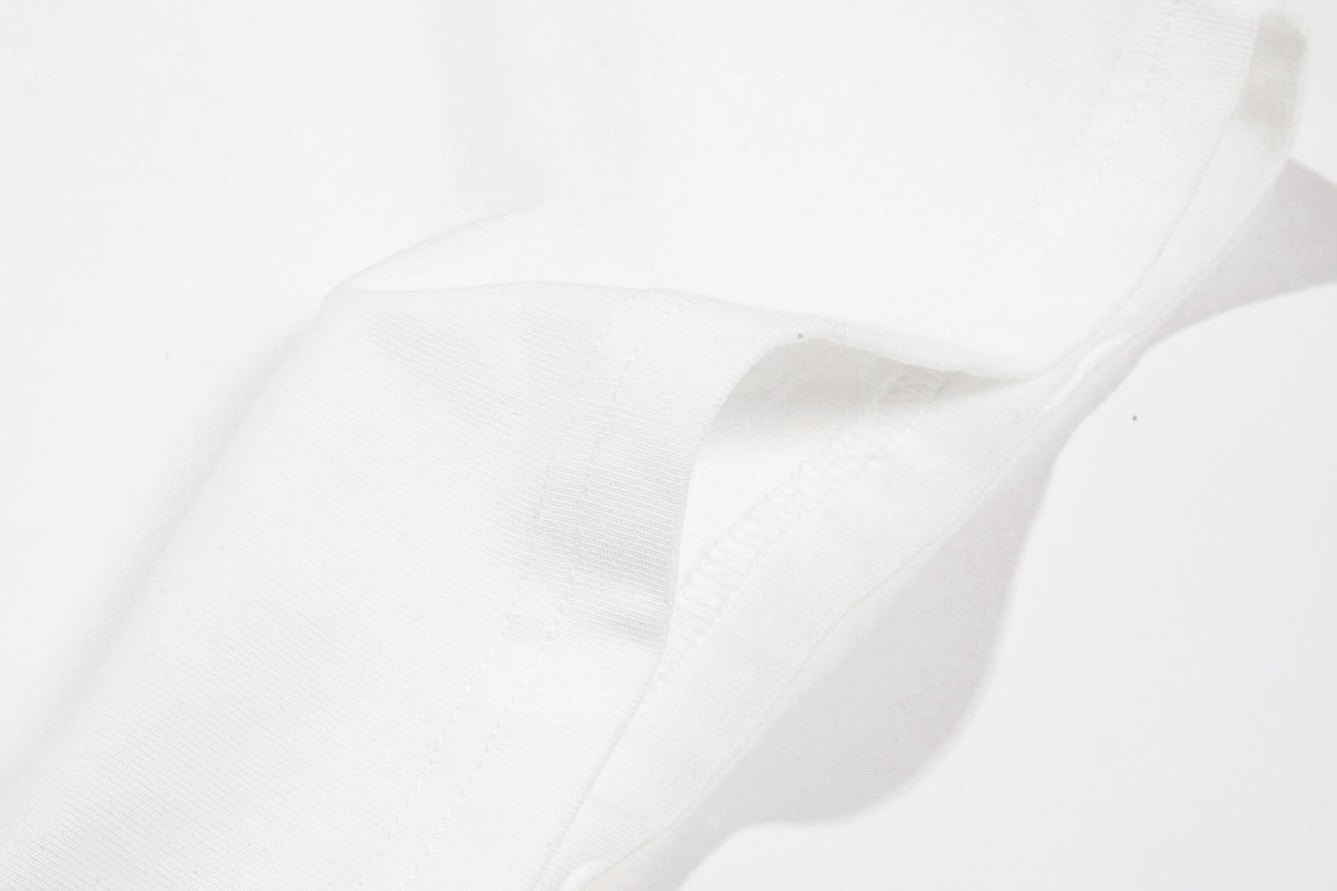 Close-up of a white T-shirt seam and folded fabric edge.