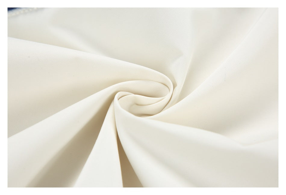 Close-up of smooth off-white fabric arranged in soft folds.
