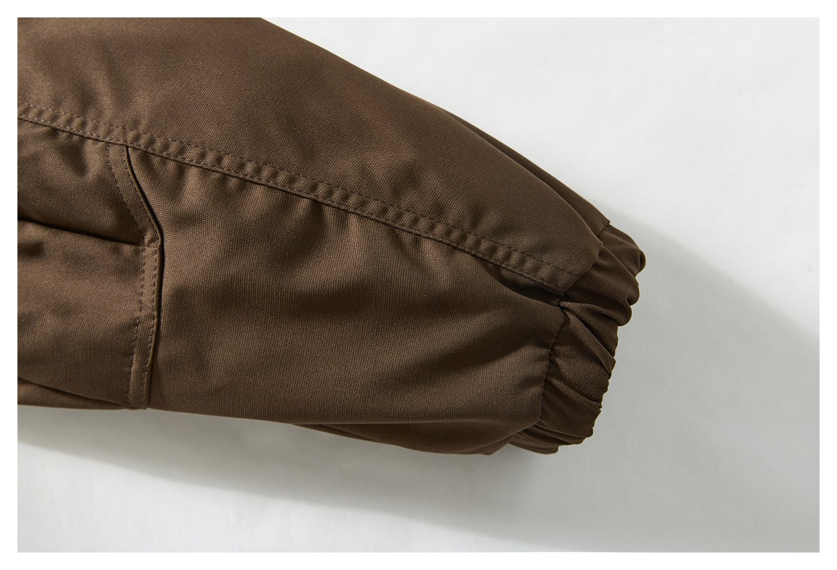 Close-up of the brown jacket's sleeve ending in a gathered elastic cuff.