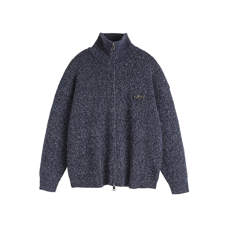 Front view of a navy marled zip-front knit sweater with a high collar and small metal chest badge.