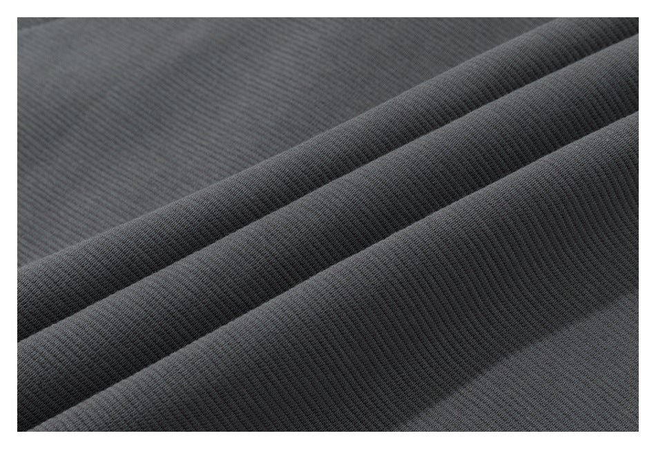 Macro view of charcoal knit fabric folded to show its fine ribbed texture.