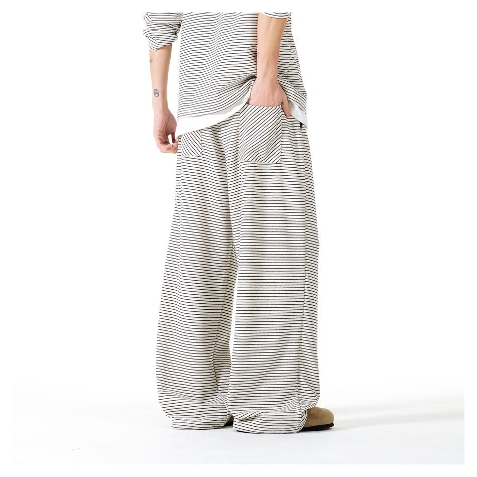 Back view of a model wearing cream wide-leg pants with thin dark stripes and a matching top.