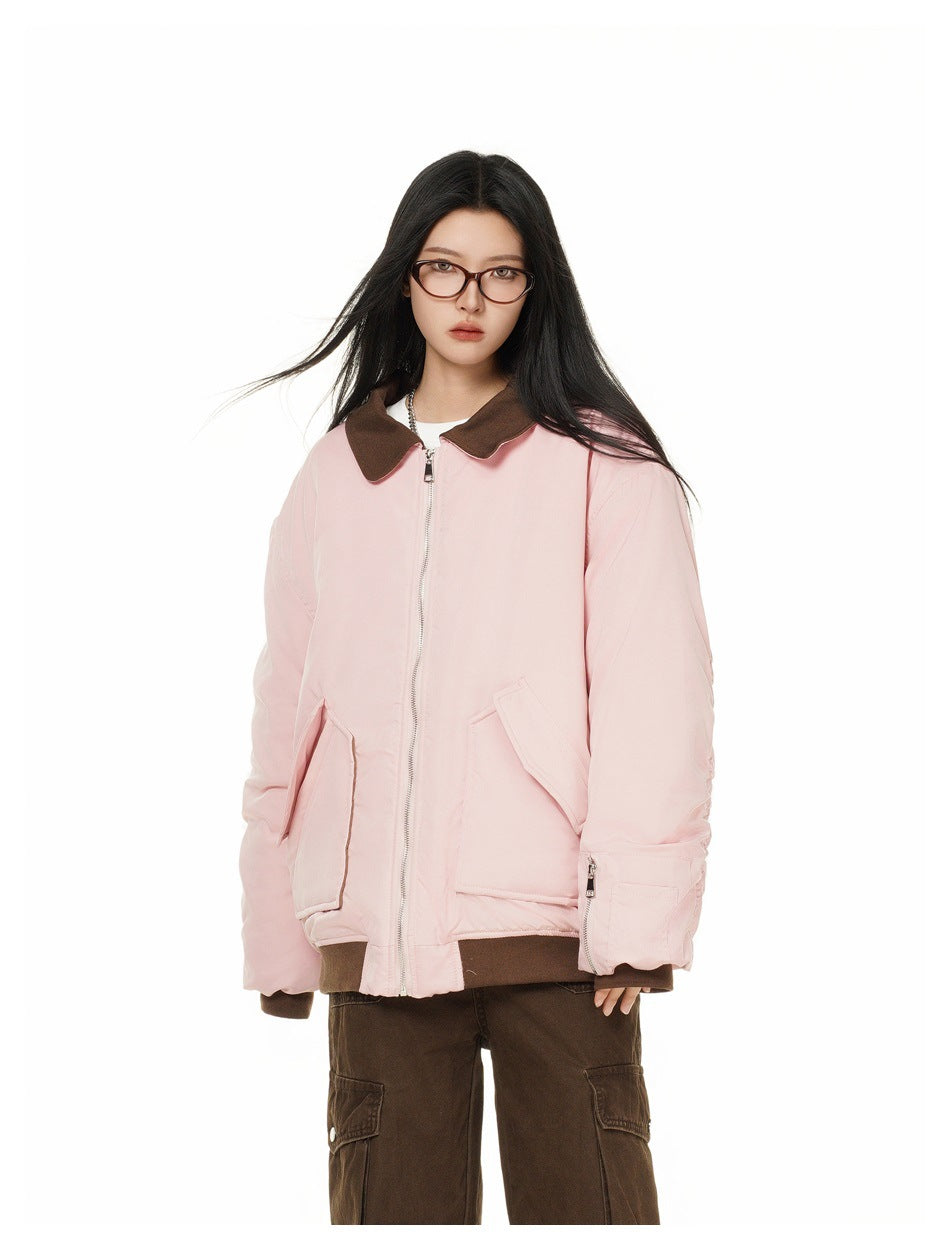 Model wearing an oversized pink jacket with brown collar and ribbed hem, front view with brown cargo pants