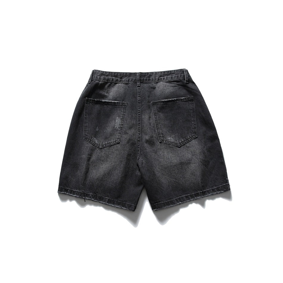 Faded black denim shorts flat lay, back view, with two patch pockets and frayed hems