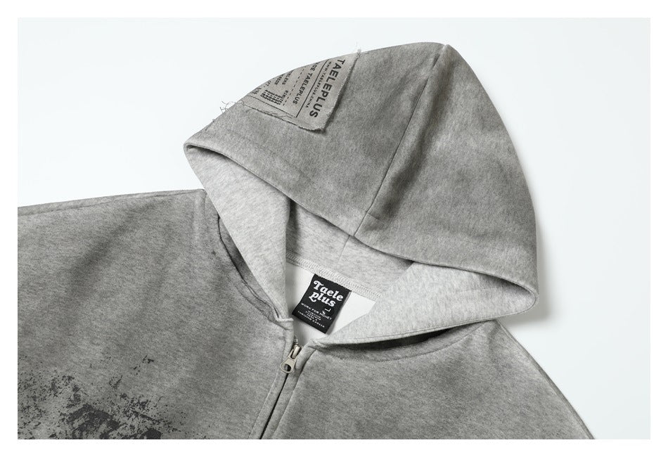 Close-up of a gray hood, zipper, and sewn labels on a zip-up hoodie.