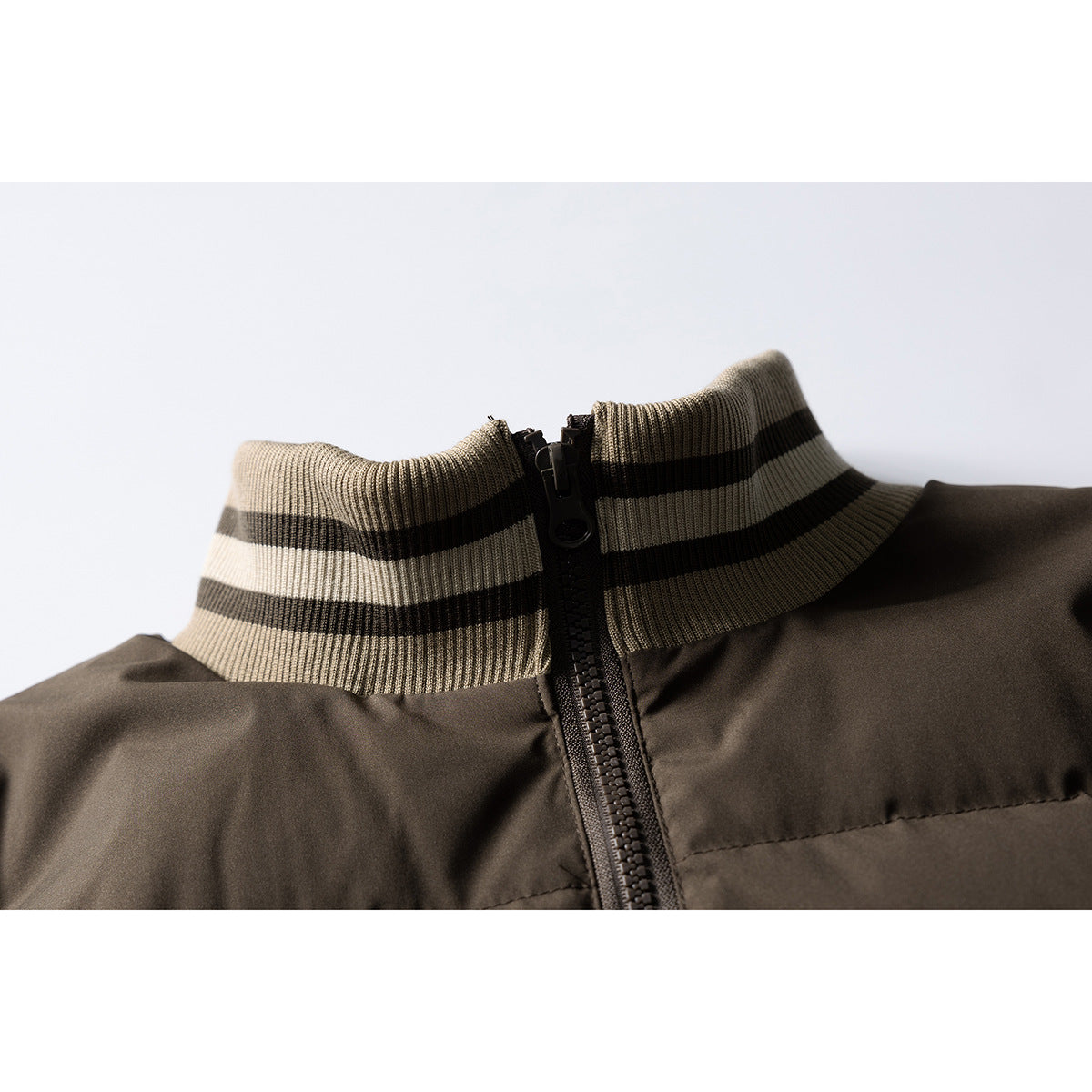 Close-up of a dark brown padded jacket's striped stand collar and front zipper.