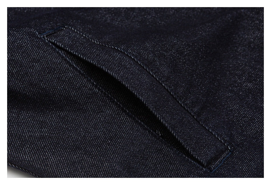 Close-up of a stitched pocket opening on dark indigo denim.