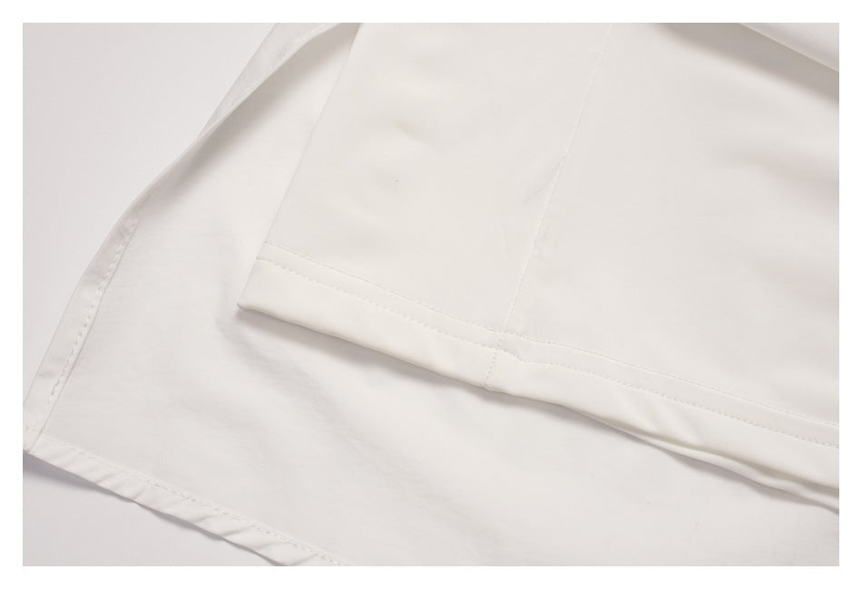 Close-up of overlapping white skirt panels and stitched hems.