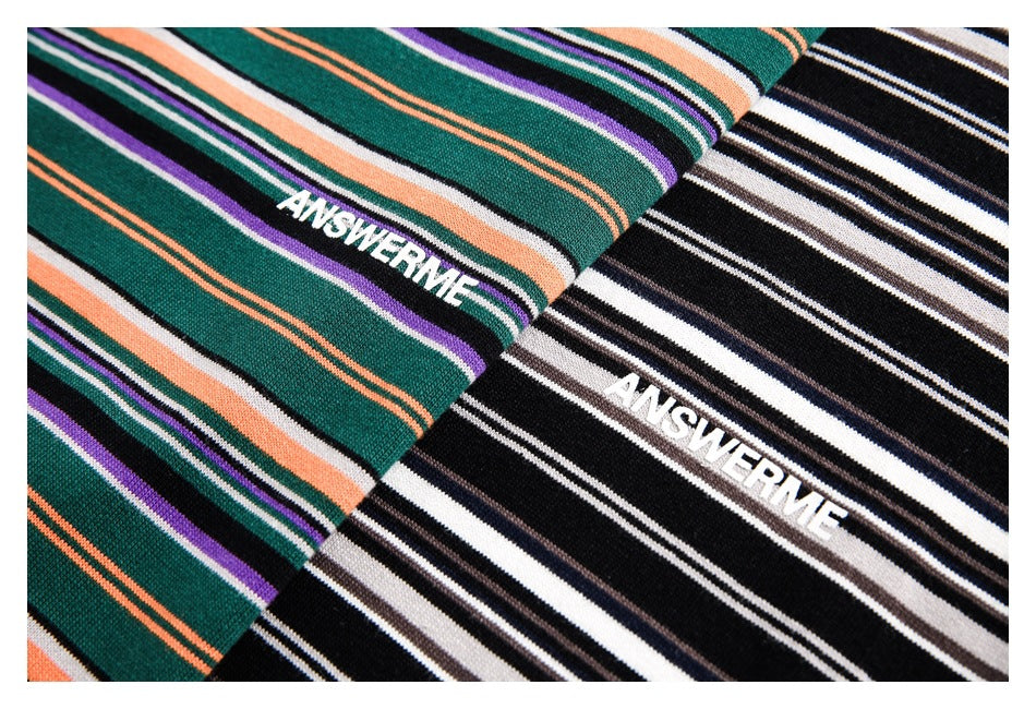 Close-up of two striped knit garments: one dark green with orange, purple, black and white stripes, and one black and white.