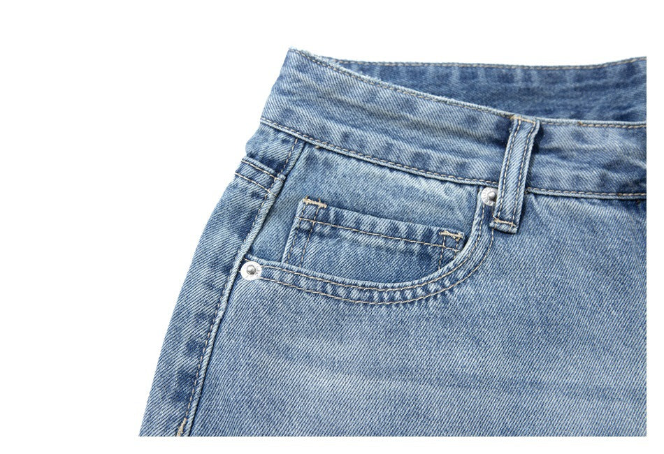 Close-up of light blue washed jeans showing the waistband, belt loop, and front coin pocket.