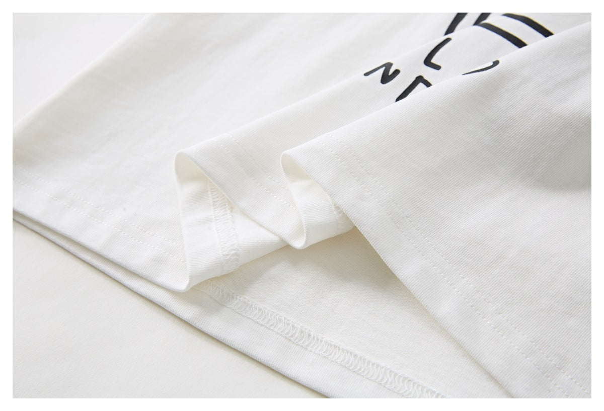 Close-up of white T-shirt fabric showing the sleeve and hem stitching.
