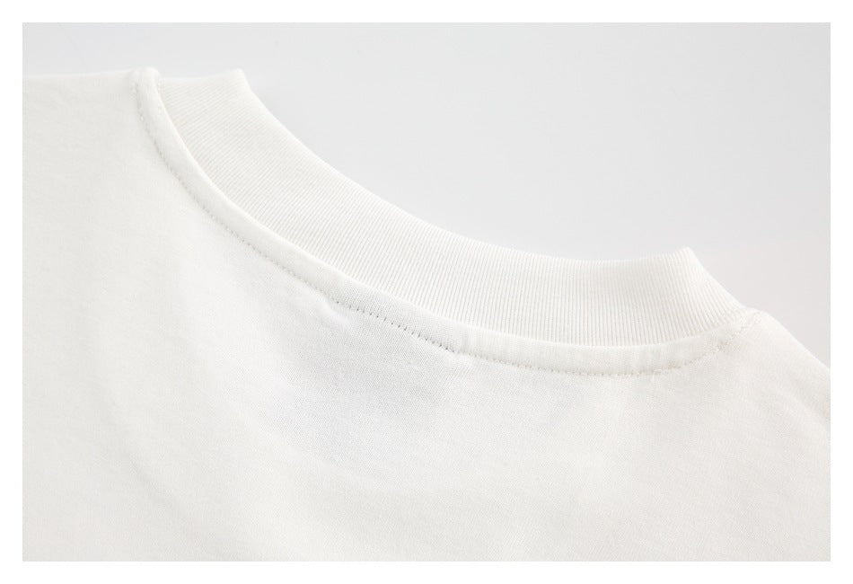 Close-up of a white crew neckline with ribbed collar trim and visible stitching.