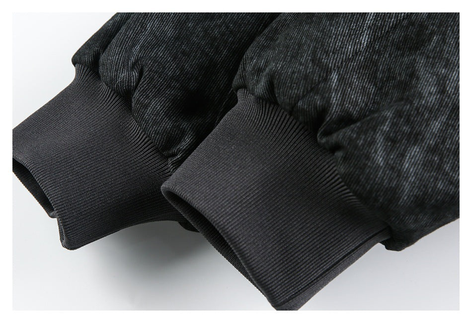 Close-up of two dark rib-knit jacket cuffs against the charcoal patterned fabric.