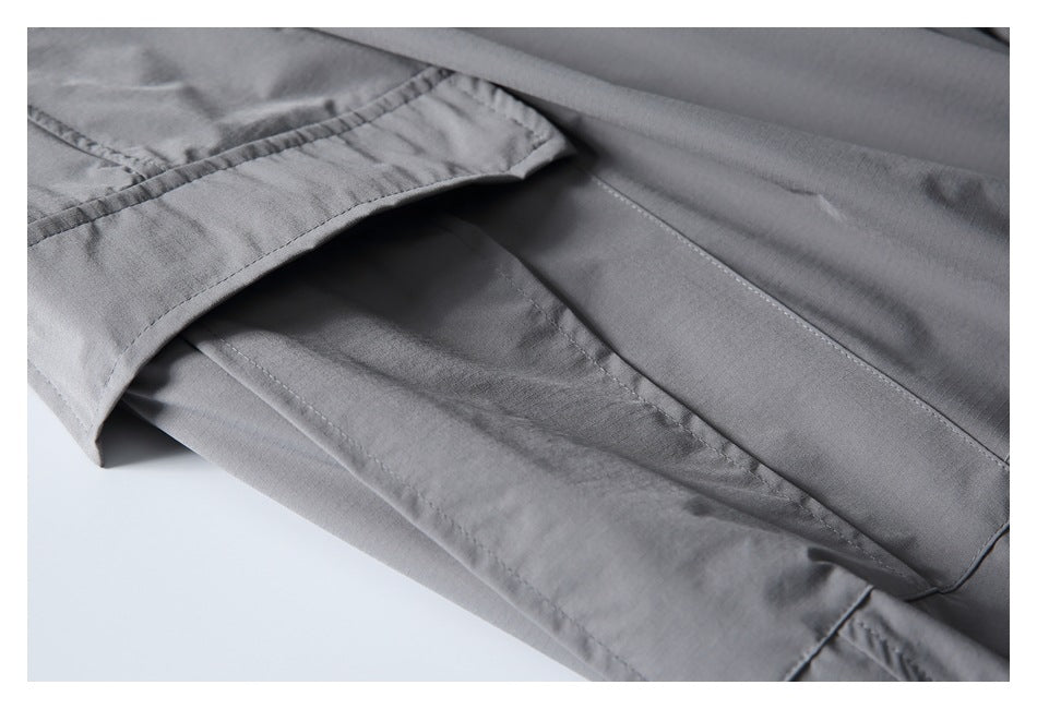 Close-up of gray pants fabric and a stitched pocket opening, shown folded to reveal the seam.