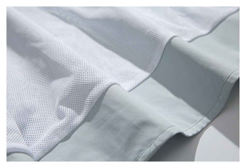 Close-up of white mesh fabric meeting a wide pale blue-gray hem with visible stitching.