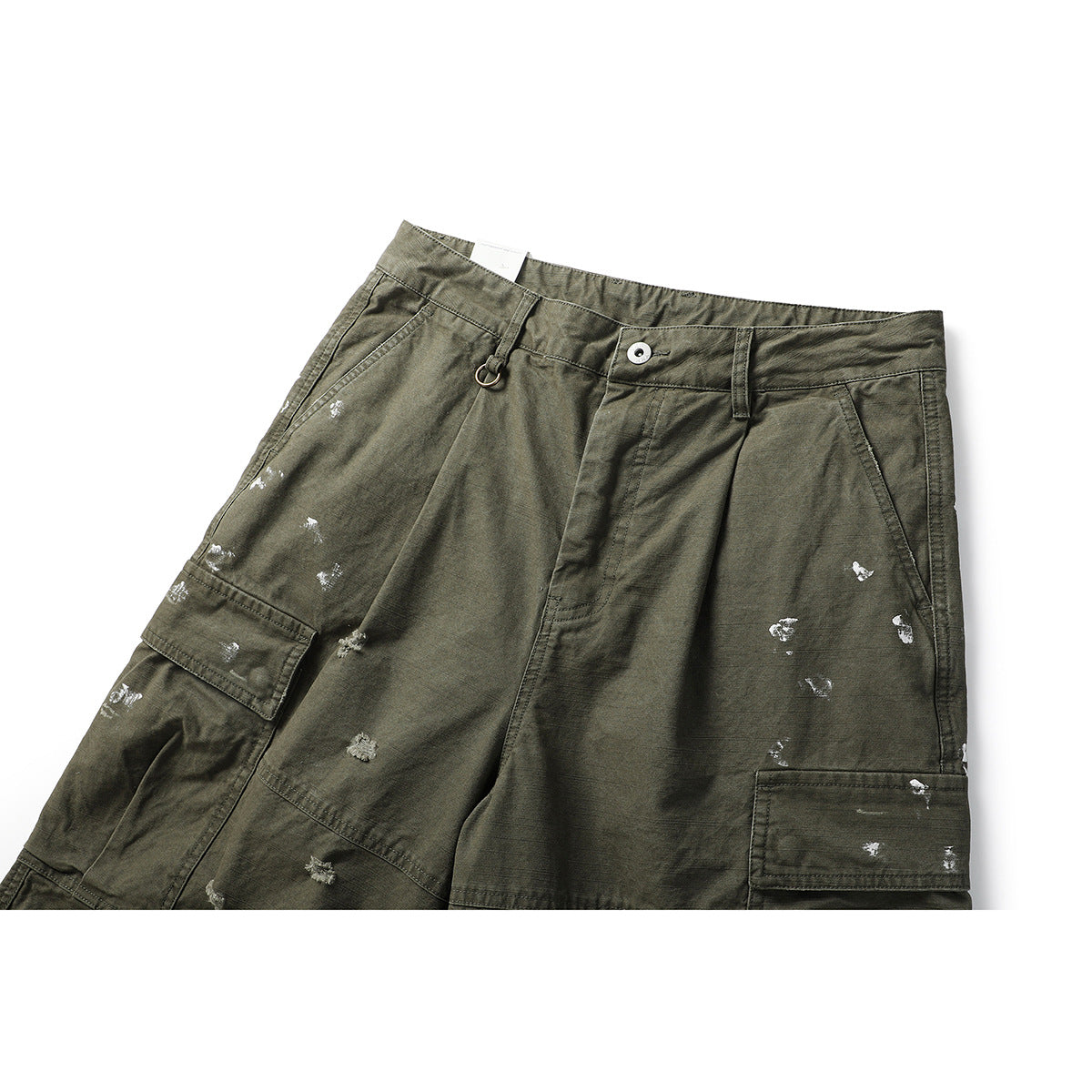 Close-up of olive cargo shorts from the front, showing the waistband, pockets, and scattered distressed marks.
