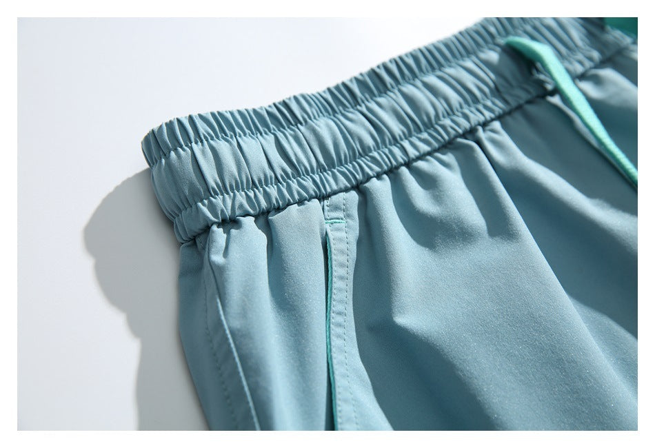 Close-up of light blue shorts showing the gathered elastic waistband and side seam.