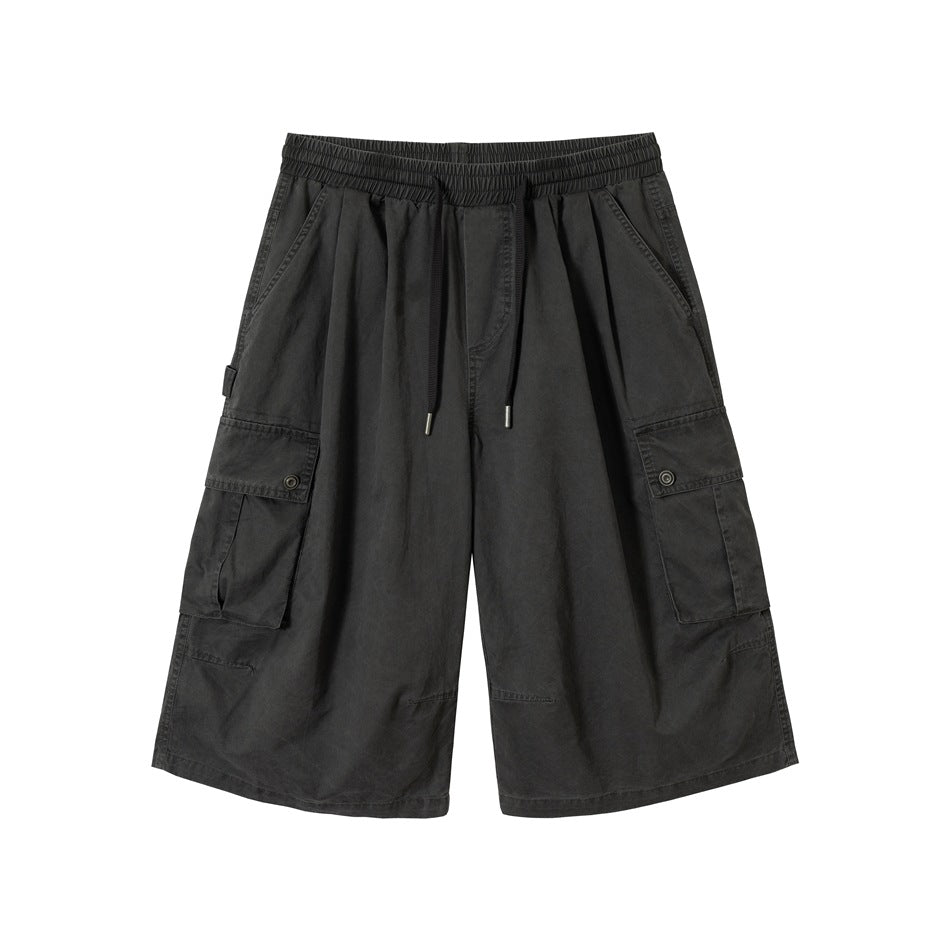 Dark grey wide-leg cargo shorts with drawstring waist and large flap side pockets, front view